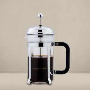 A sleek French press coffee maker with a chrome finish and black handle, filled with freshly brewed coffee, displayed against a neutral beige background
