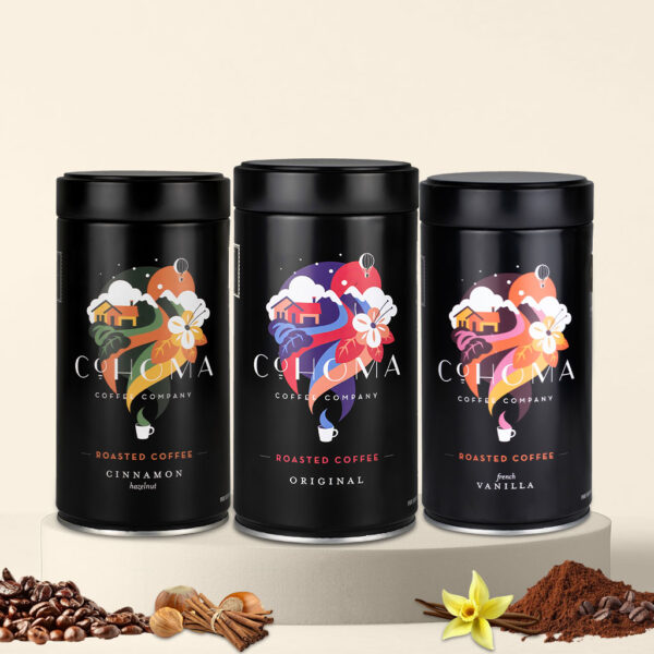 Display of three Cohoma coffee cans: Cinnamon Hazelnut, Original, and French Vanilla flavors, showcasing a variety of roasted coffee options in elegant black packaging.